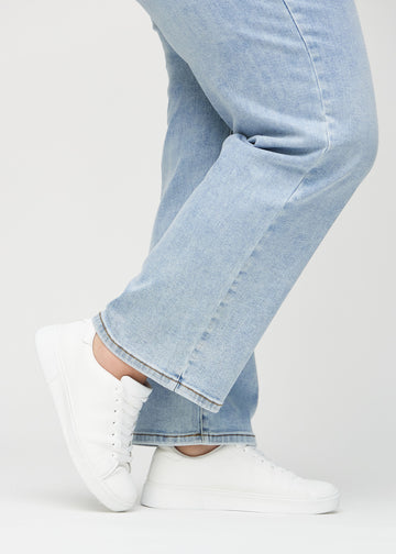 The ankles of a plus-size model, so you can see how loose the jeans fit.