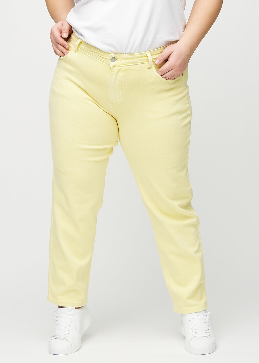 Regular jeans for women in light yellow, color Lemonades. Front view on a plus-size model, showing the classic straight-leg fit.