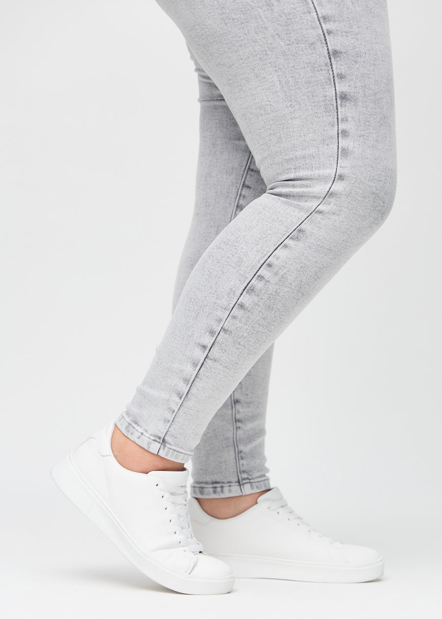 The ankles of a plus-size model, so you can see how tightly the jeans fit.