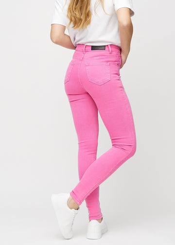 Skinny jeans for women in light pink, color Flamingos. Back view on a model, showing the full fit.