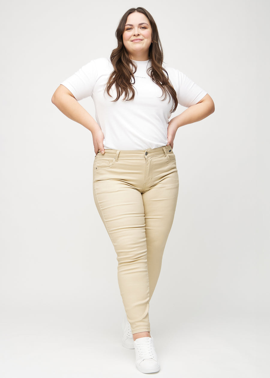 Skinny jeans for women in beige, color Gazelles. Full-length view of a plus-size model wearing the jeans.