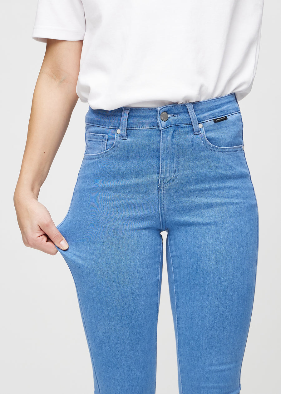 The model stretches the jeans at the thigh to show the stretch.