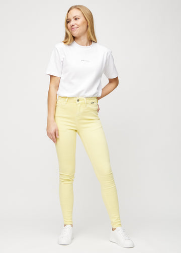 Skinny jeans for women in light yellow, color Lemonades. Full-length view of a model in the jeans.