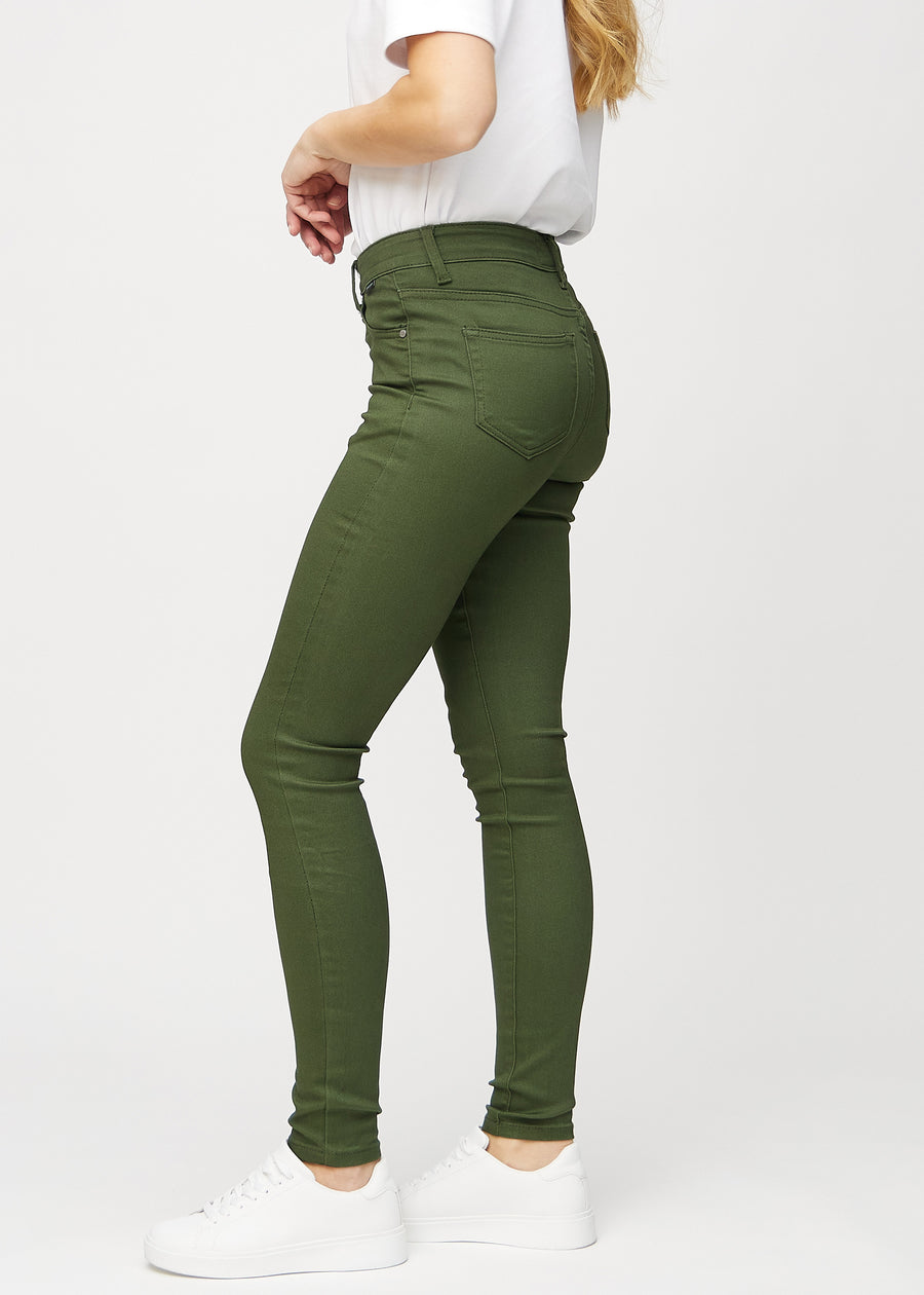 Dark green skinny jeans seen from the side on a model.