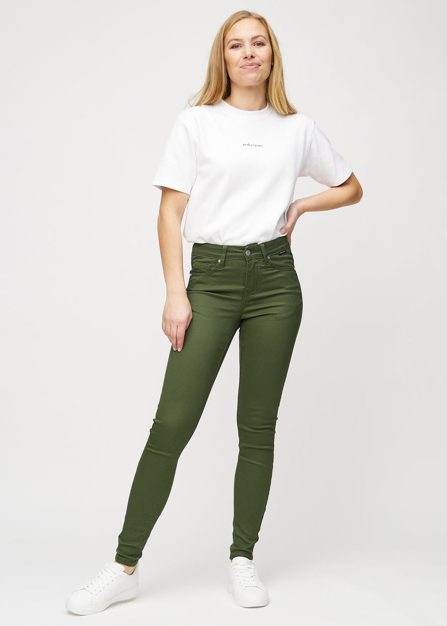 Full image of model in dark green skinny jeans.