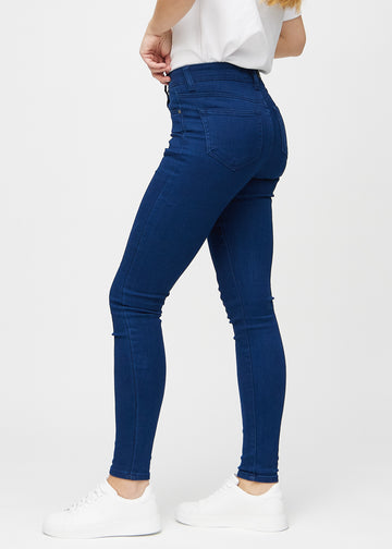 Dark blue skinny jeans viewed from the side on a model.