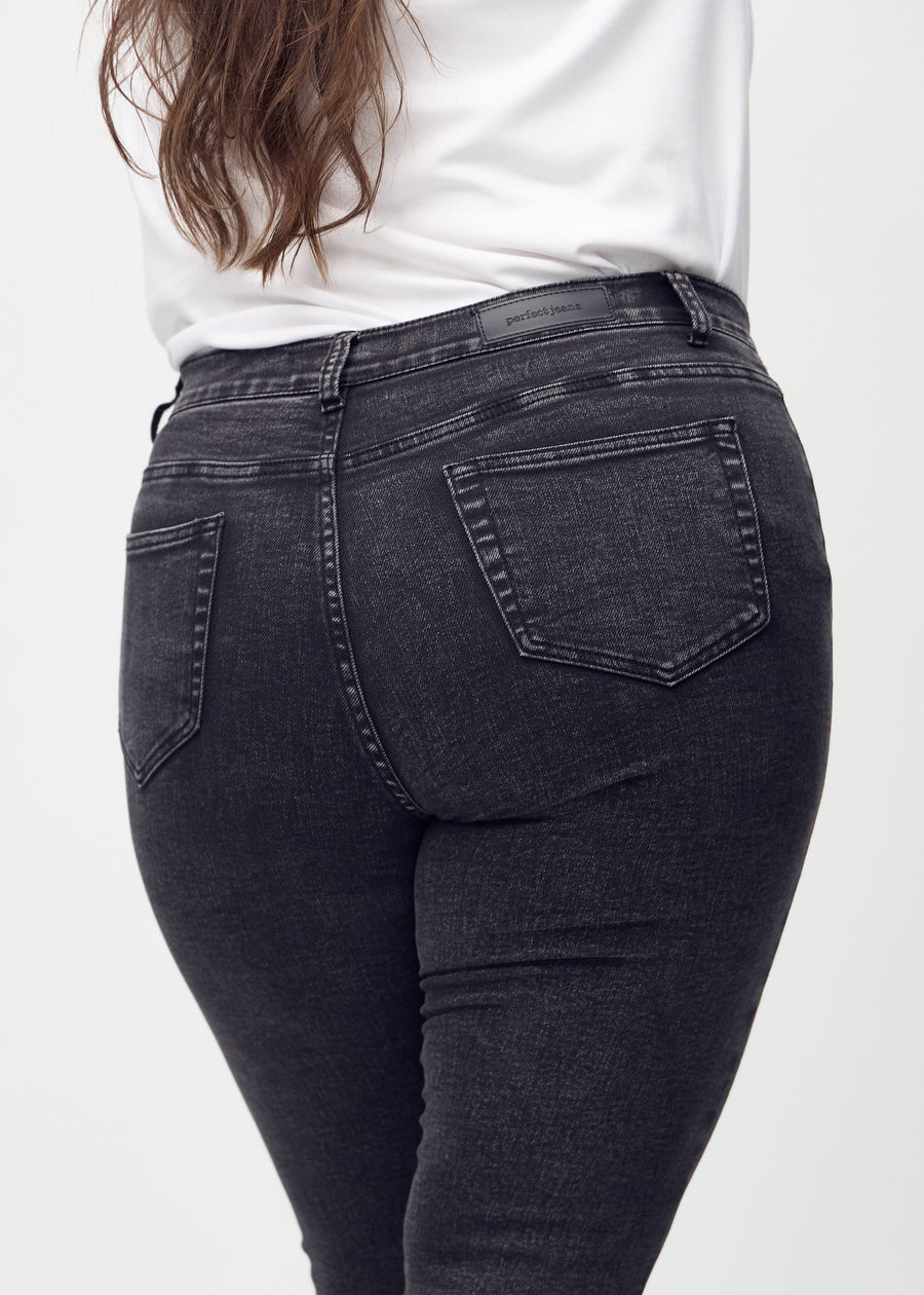 Skinny jeans for women in dark grey, color Shadows. Close-up back view on a plus-size model, showing details.