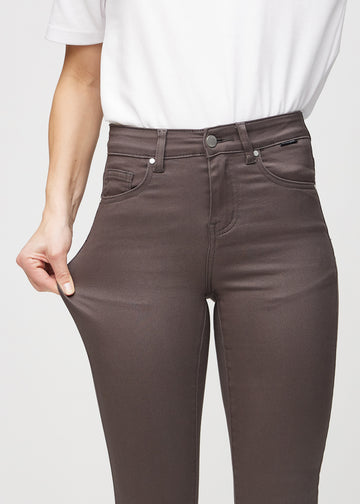 The model stretches the jeans at the thigh to show the stretch.