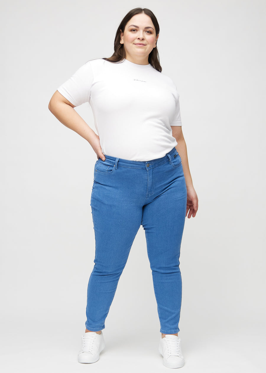 Slim jeans for women in blue, color Geraniums. Full-length view of a plus-size model wearing the jeans.