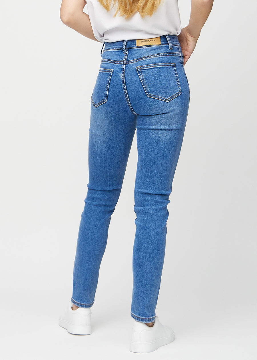 Slim jeans for women in blue, color Rivers. Back view on a model, showing the overall fit.