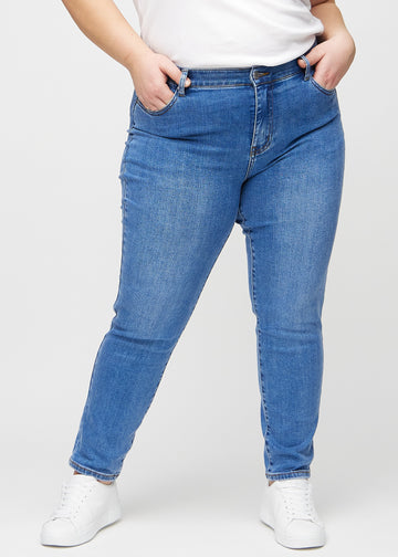 Slim jeans for women in blue, color Rivers. Front view on a plus-size model, showing a close fit through the leg with a little more room at the ankle.