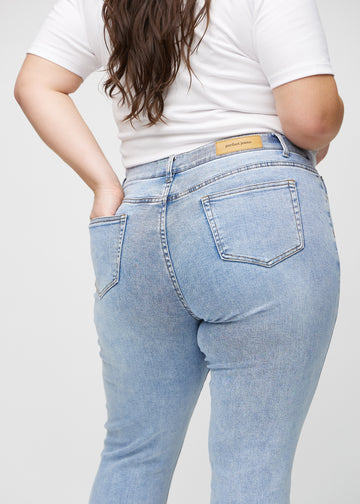 Slim jeans for women in light blue, color Waves. Close-up back view on a plus-size model, showing the details.