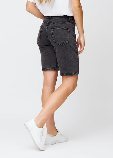 Woman in knee-length dark grey denim shorts, seen from the back