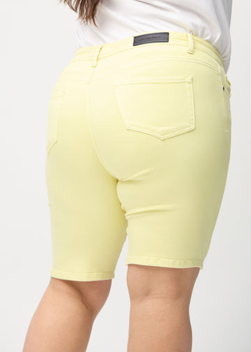 Light yellow skinny middle shorts seen from the back close up on a plus-size model to show details.