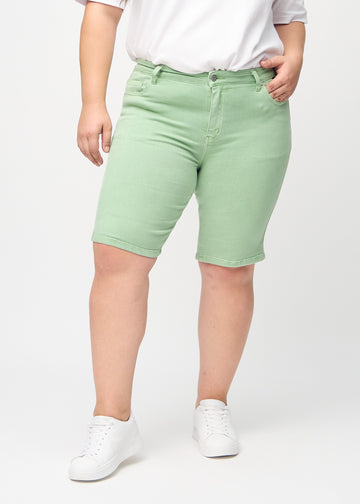 Light green skinny middle shorts, model name Mints, which fit tightly around the thigh and end just above the knee on a plus-size model, seen from the front.