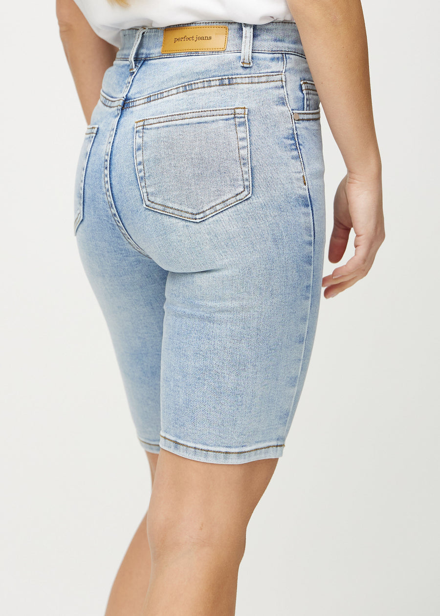 Light denim skinny middle shorts seen from the back close up to show details.