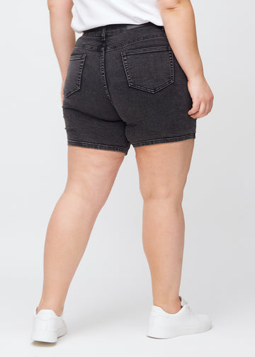 Dark grey denim skinny short shorts seen from the back on a plus-size model, so the entire product can be seen.