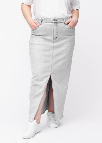 Long light grey denim skirt for women in the color Ashes. Front view on a plus-size model, showing the straight fit from the hips and a front slit starting below the knee.