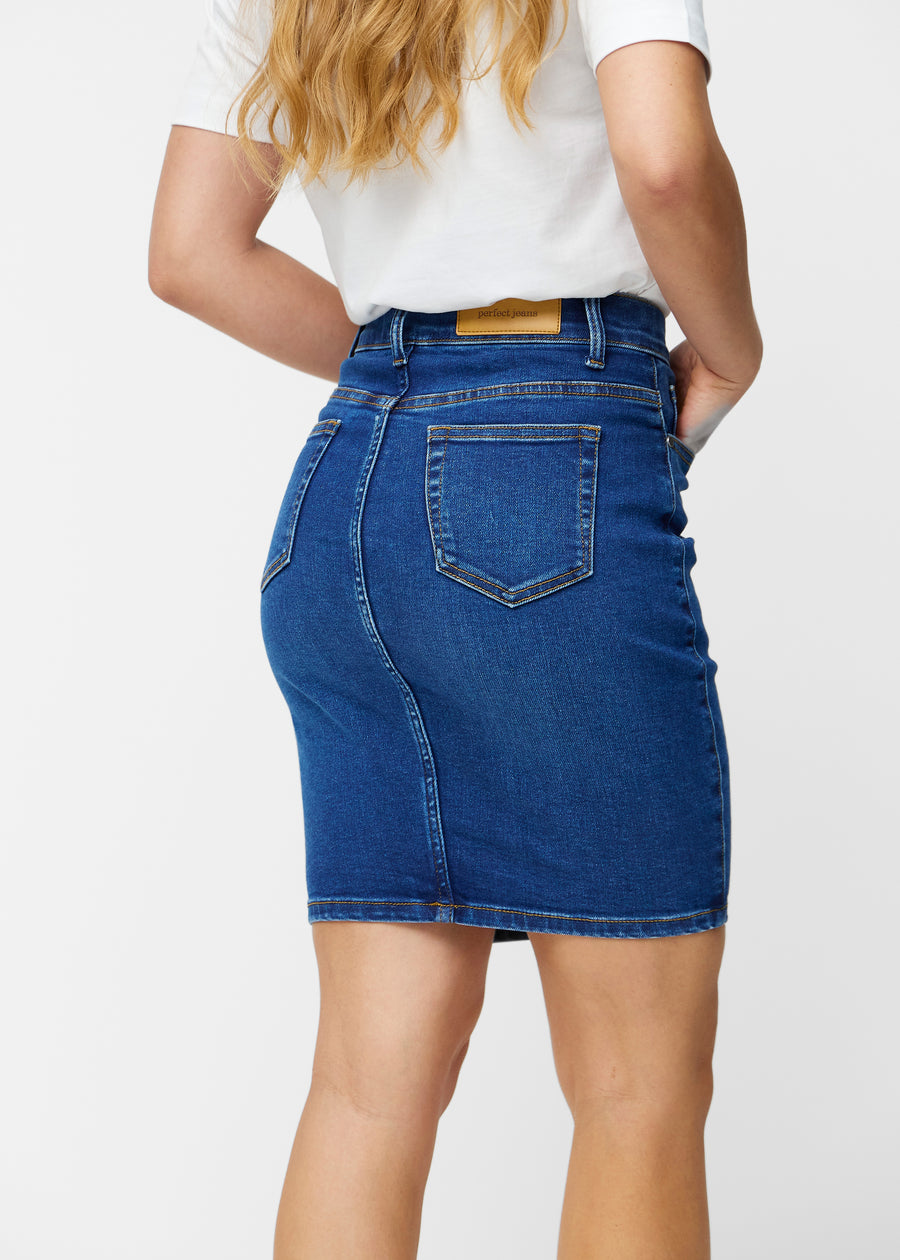 Mørkeblå, tætsiddende og knælang denimnederdel set bagfra tæt på for at vise detaljer.