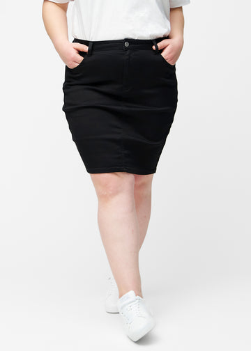 Sort, tætsiddende og knælang jeansnederdel set forfra på plus-size model.
