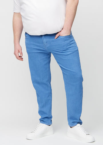 Blue regular jeans, model name Geraniums, which goes straight down the leg on a plus-size model, seen from the front.
