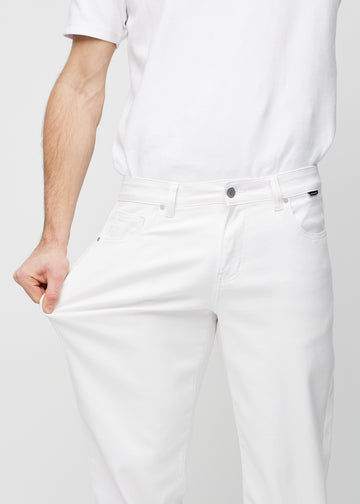 The model stretches the jeans at the thigh to show the stretch.