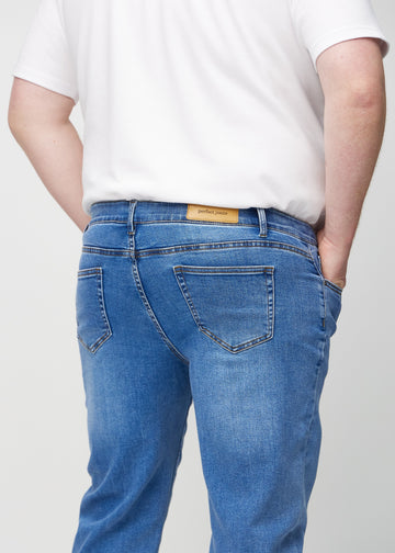 Denim regular jeans seen from the back close up on a plus-size model to show details.