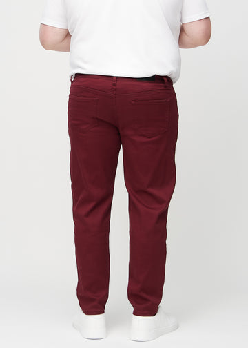 Dark red regular jeans seen from the back on a plus-size model, so the entire product can be seen.