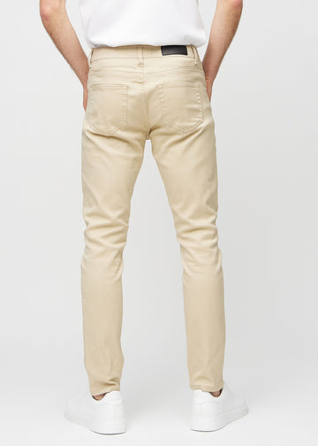 Beige slim jeans viewed from the back to show the full product.