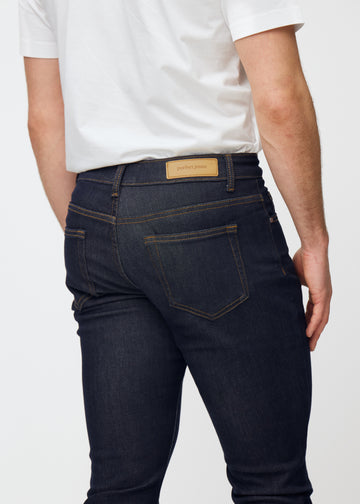 Deep dark blue denim jeans for men in the color Midnights seen from the back close up to show fit and details.