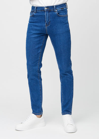 Dark blue denim slim jeans, model name Oceans, fitted closely along the legs , front view.