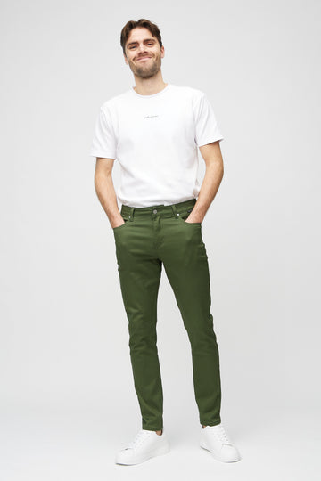 Full-length view of a model in dark green slim jeans.