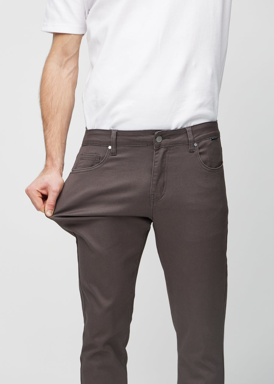 Model stretches the jeans at the thigh to show the fabric&