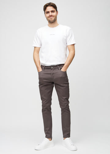 Full-length view of a model in grey-brown slim jeans.