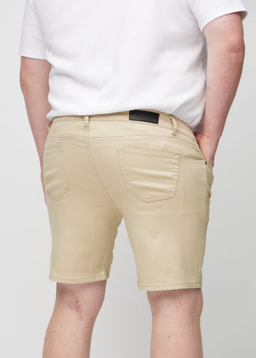 Beige middle-slim shorts seen from the back up close on a plus-size model to show details.