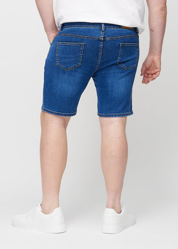 Dark denim middle-slim shorts seen from the back on a plus-size model, so the entire product can be seen.