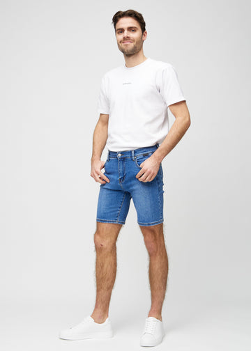 Full image of model in denim middle-slim shorts.