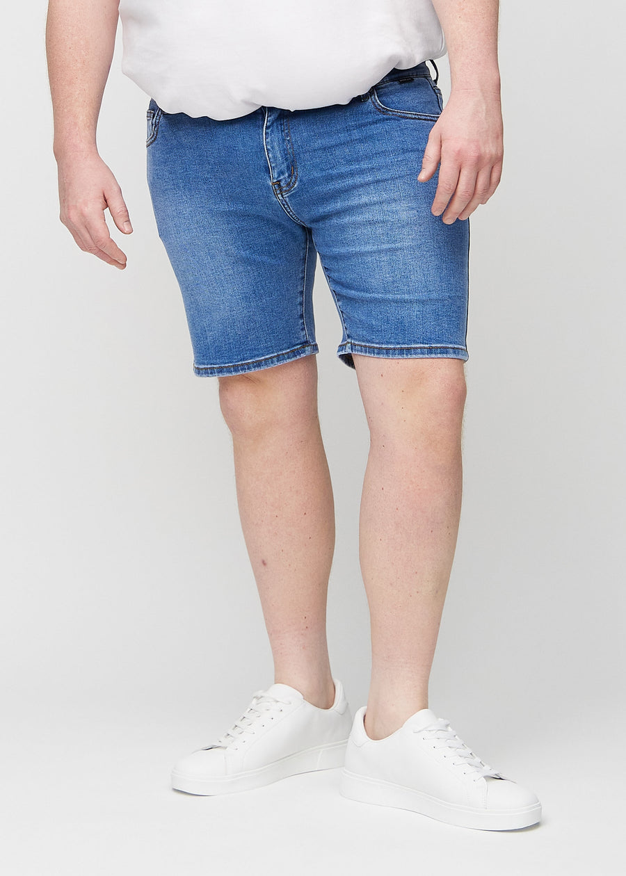 Denim middle-slim shorts, which fit straight along the thigh and end just above the knee on a plus-size model, seen from the front.