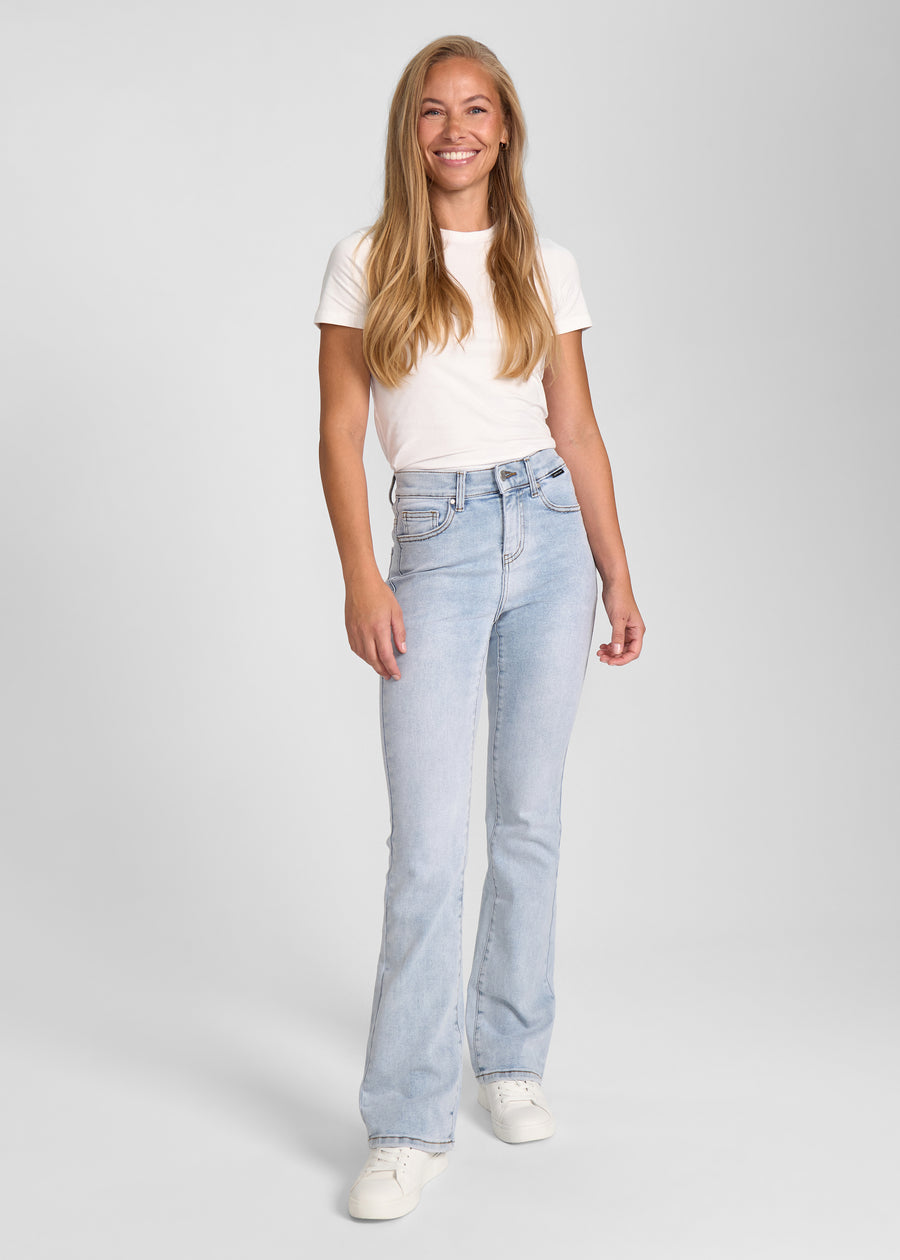 Fuldt billede af model i lyseblå denim bootcut jeans.