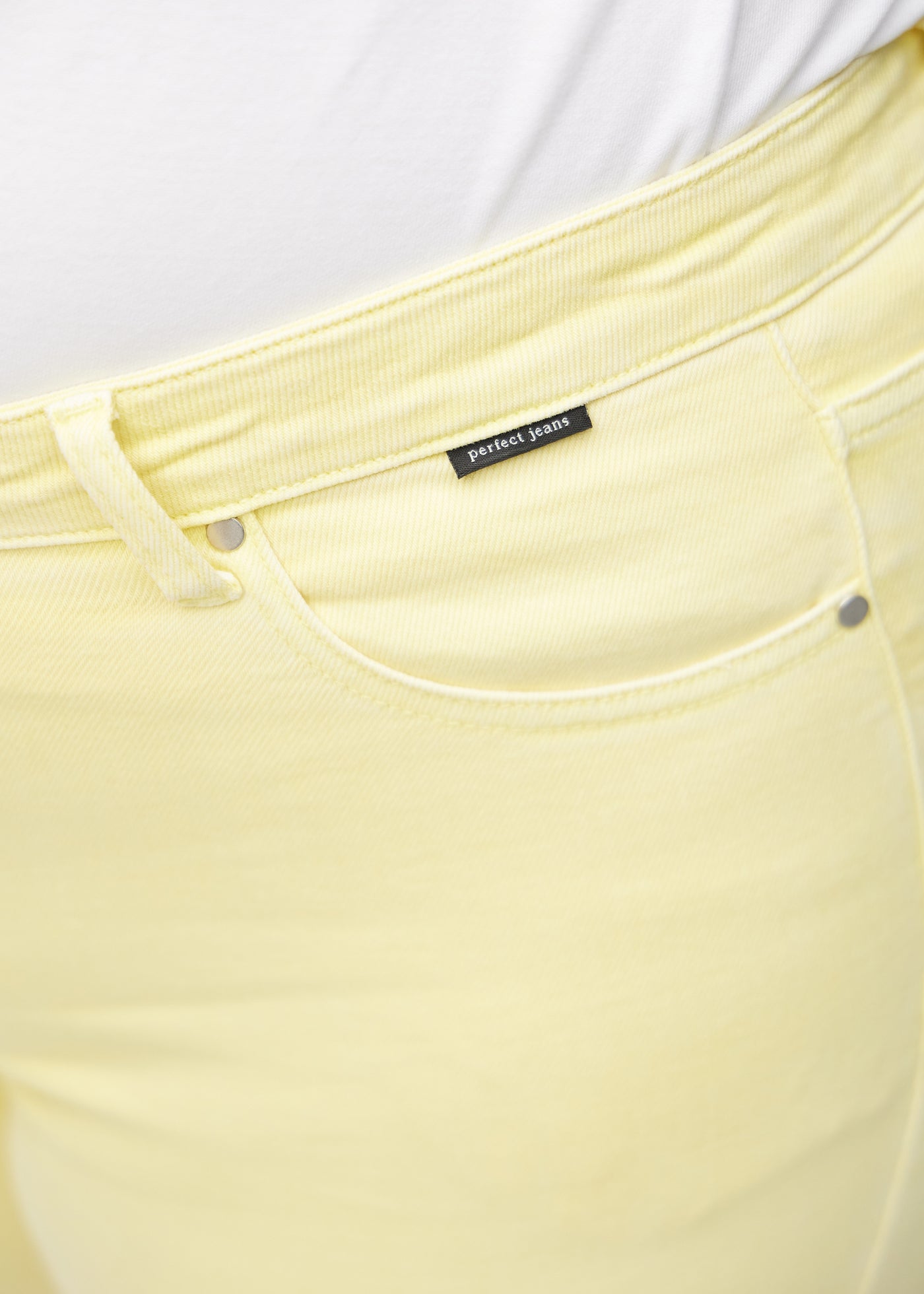 Detaljebillede af forlommen på de lysegule slim capris i farven Lemonades – logo og snit fremhævet.