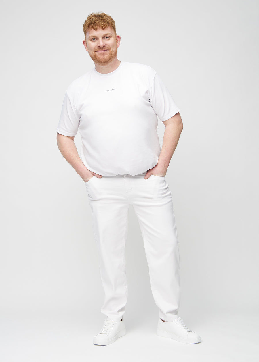 Plus-size model går ind i billedet, strækker i jeansene, viser dem frem ved at dreje rundt, og forlader derefter billedet.