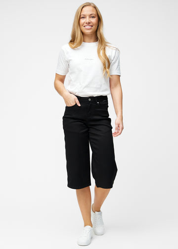 Model viser løse, sorte capris i farven Ravens i bevægelse og demonstrerer pasform og materiale.