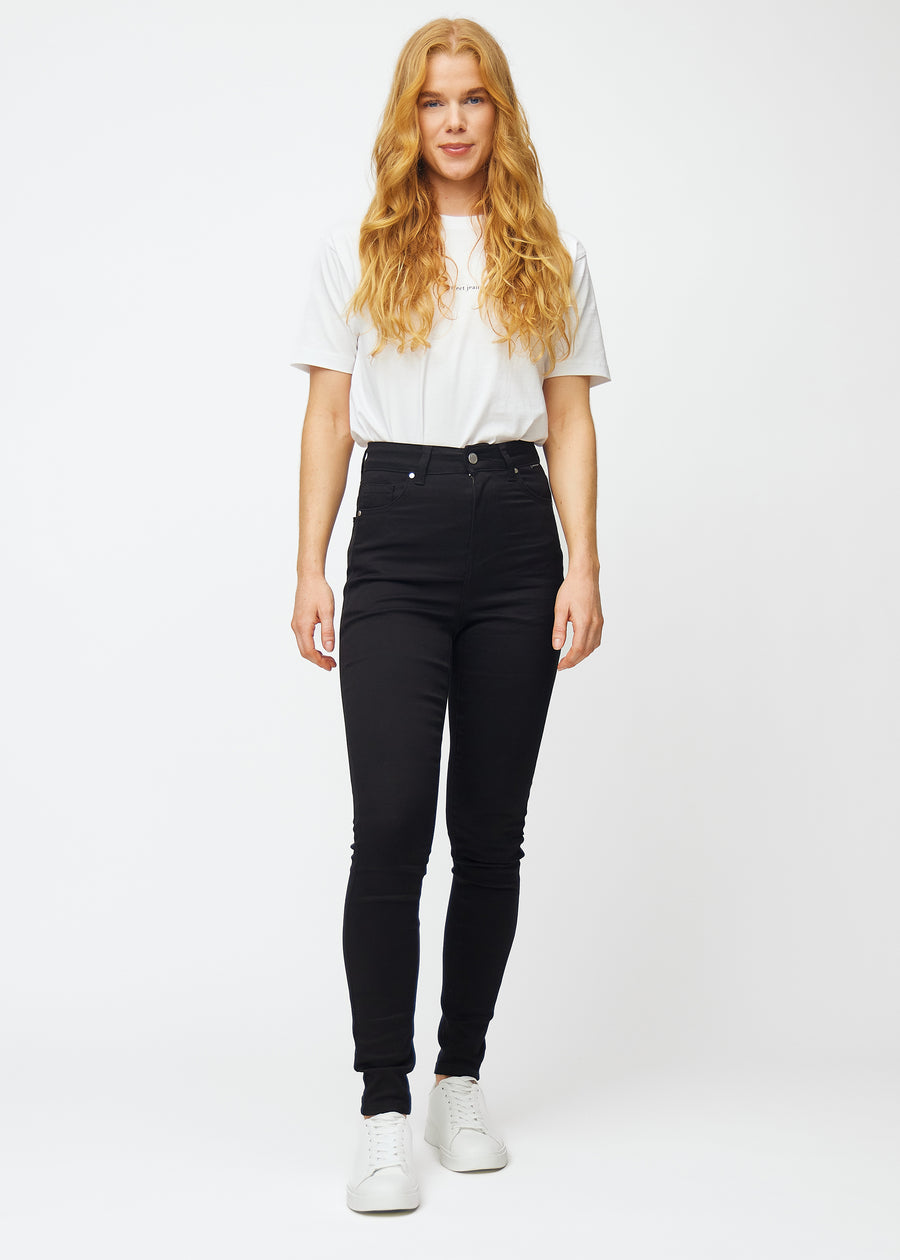 En model i sorte high rise skinny jeans til kvinder i farven Ravens vises i bevægelse.