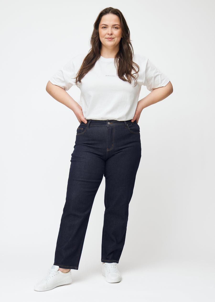 Plus-size model viser dyb mørkeblå denim jeans til kvinder i farven Midnights med regular pasform i bevægelse.