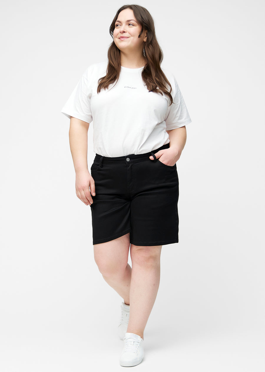 Plus-size model viser løse, sorte shorts i farven Ravens i bevægelse og demonstrerer pasform og materiale.