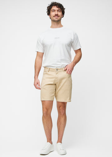 Model viser beige shorts til mænd i farven Gazelles med regular pasform i bevægelse.